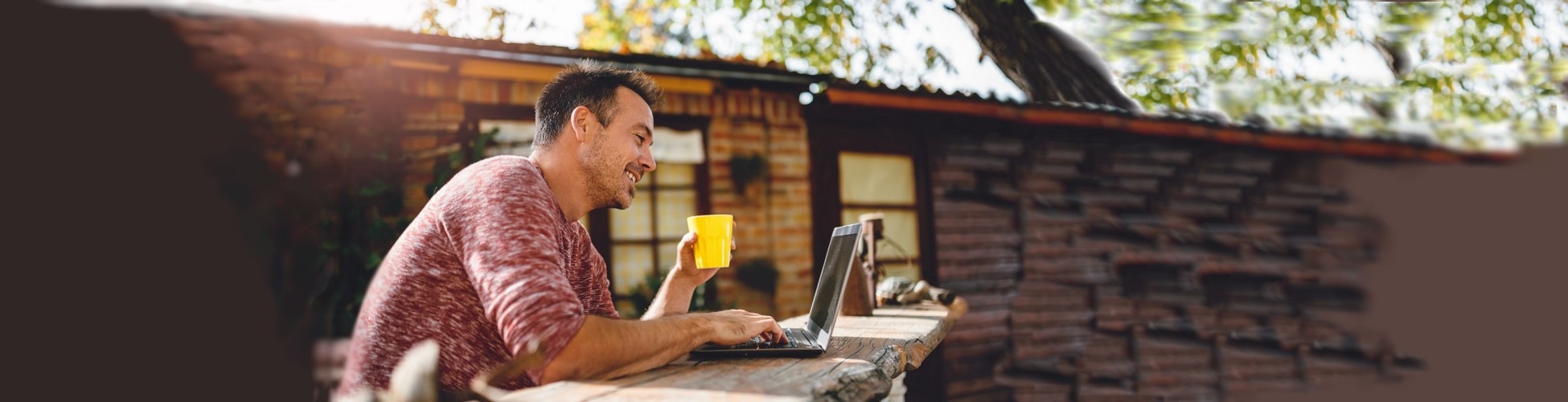 slider homme qui gère ses comptes et placements en ligne avec un logiciel de budget à l'extérieur sur son portable